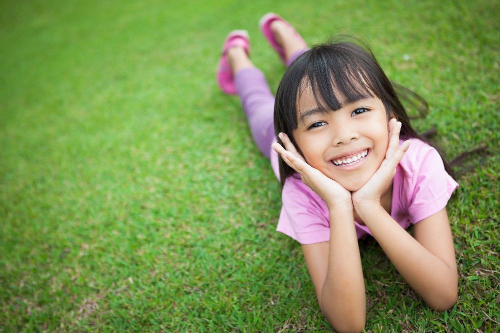 Pediatric dental patient smiling outside near Springfield IL