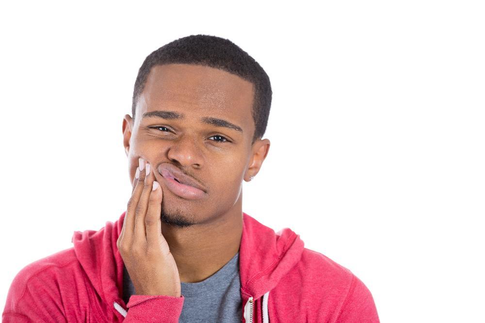 Patient holding his face in pain from dental emergency near Springfield IL