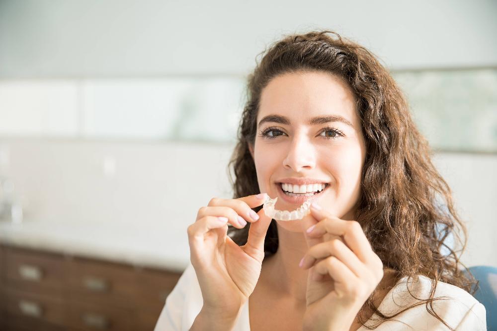 Woman holding tray of Invisalign aligners in Springfield IL