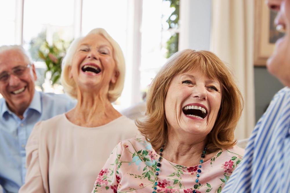 Woman wearing dentures at a dinner party with her friends near Springfield iL