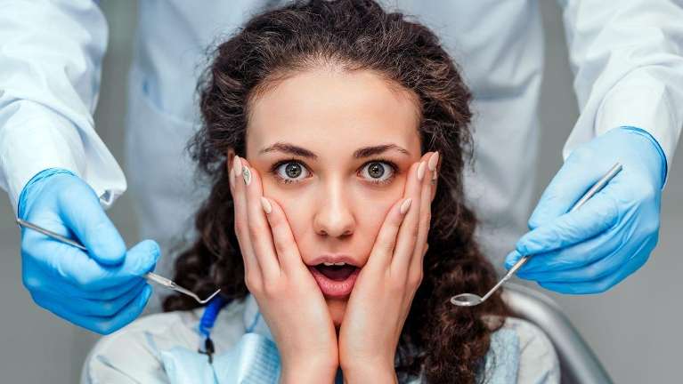 Woman holding her cheeks to calm down during dental emergegncy