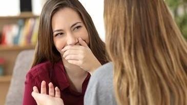 woman covering mouth with hand | dentist near me